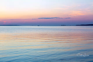 Vibrant colors pre-sunrise caused when the sunlight interacts with the earth's atmosphere results in a serene image of the the sky reflecting on the ocean