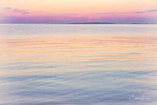 Vibrant colors pre-sunrise caused when the sunlight interacts with the earth's atmosphere results in a serene image of the the sky reflecting on the ocean
