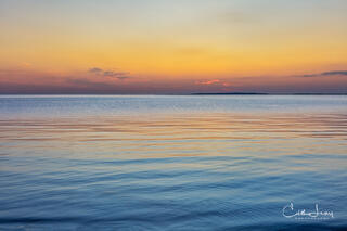 Vibrant colors pre-sunrise caused when the sunlight interacts with the earth's atmosphere results in a serene image of the the sky reflecting on the ocean