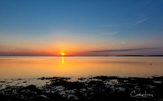 The sun breaking through the horizon on Fuller Street beach in Martha's Vineyard