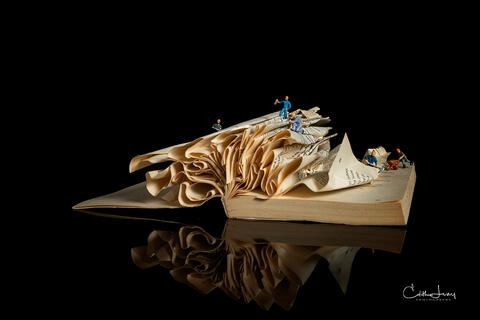 Fine art photo of an abstract folded book, featuring miniture figures forming geometric patterns , created by Toronto based photographer, Edith Levy