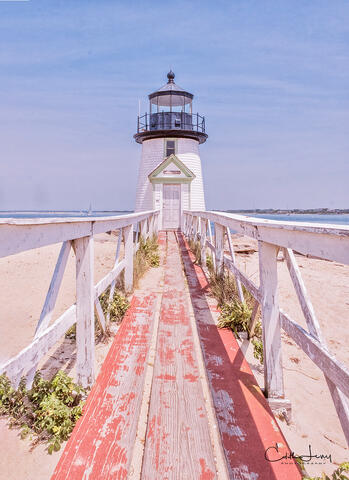 Brant Point lighthouse in Nantucket looks beautiful against the blue sky and ocean in the background